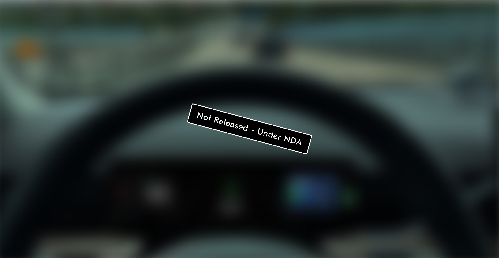 Blurred view over the steering wheel toward the road and driver display, with a Not Released, Under NDA stamp across it