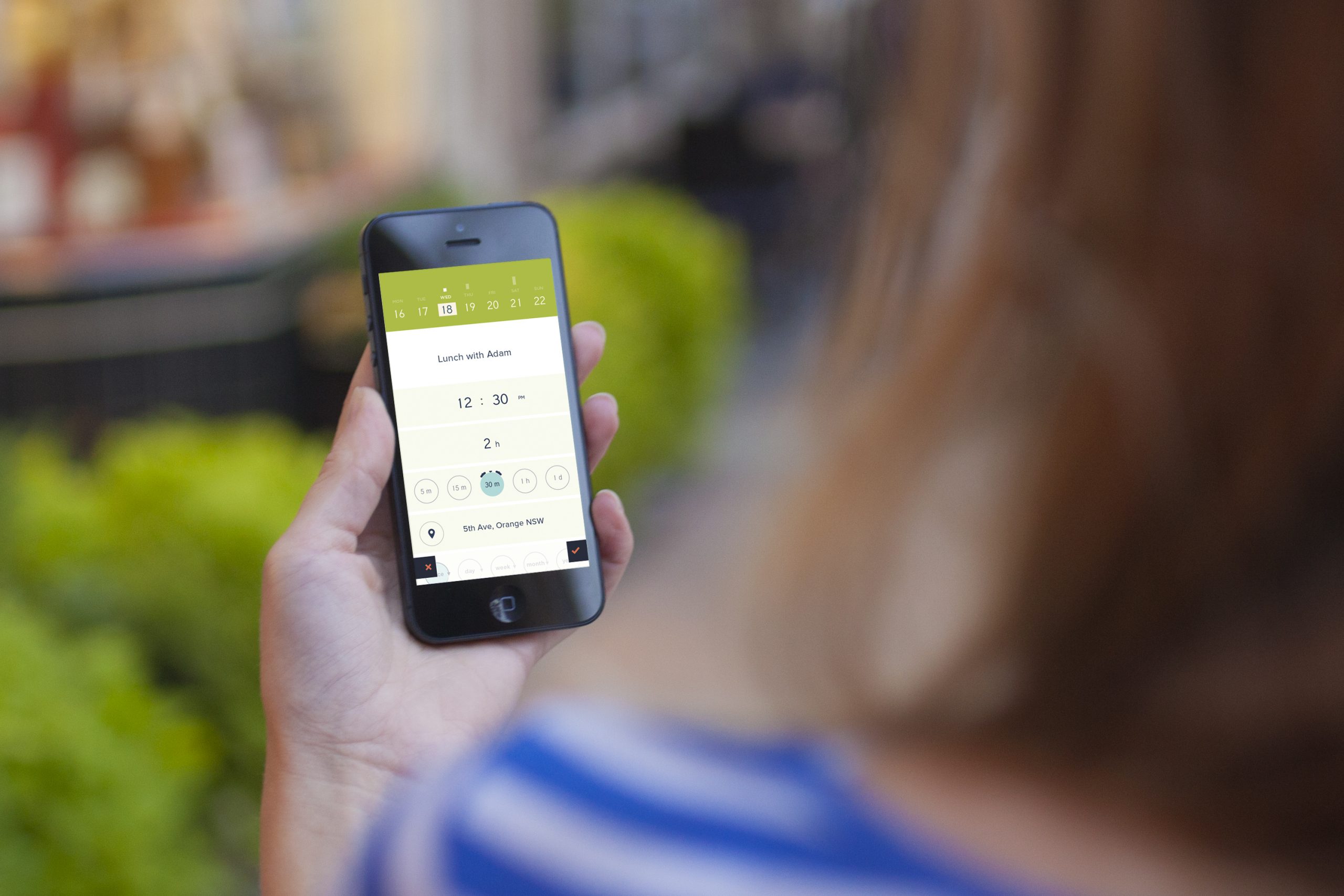 Person holding a phone showing Peek Calendar's event creation screen