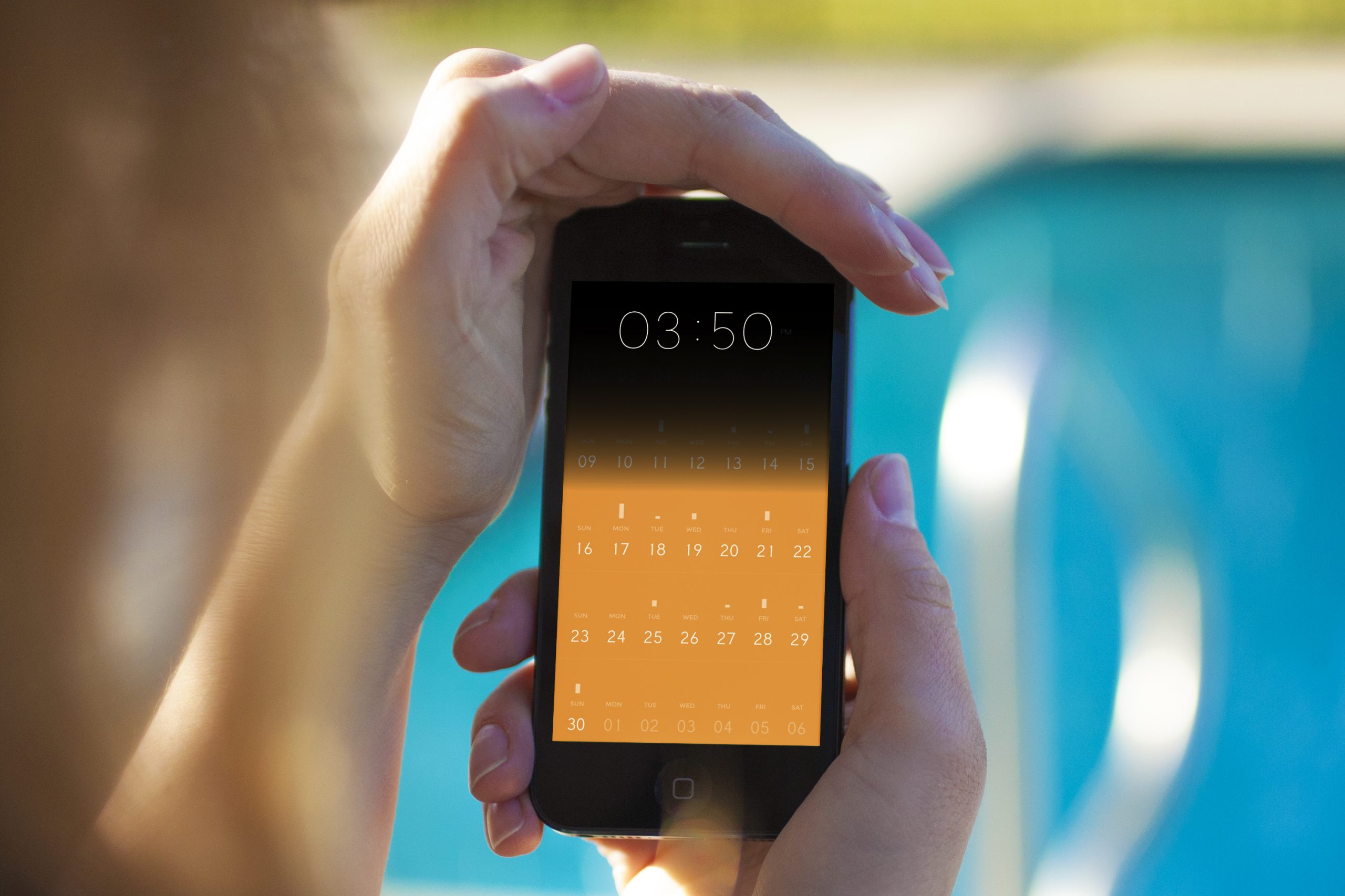 Person holding a phone showing Peek Calendar's month view by a pool