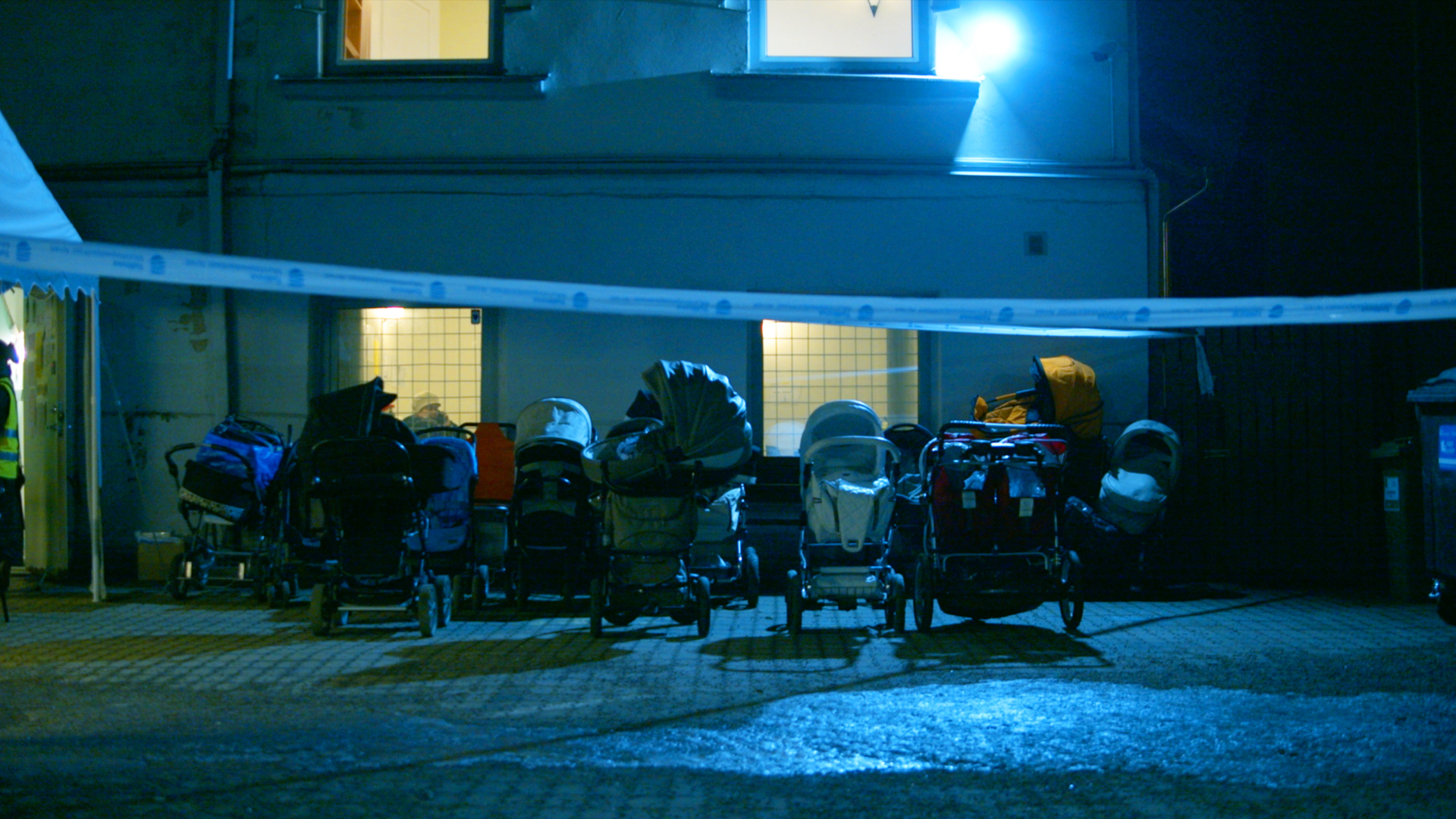 Rows of strollers lined up at night behind police tape